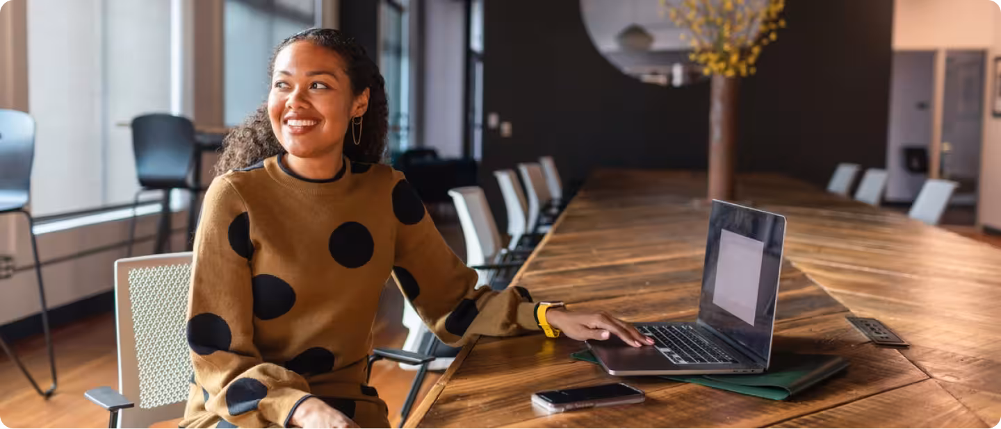 Smiling woman sitting at empty conference table