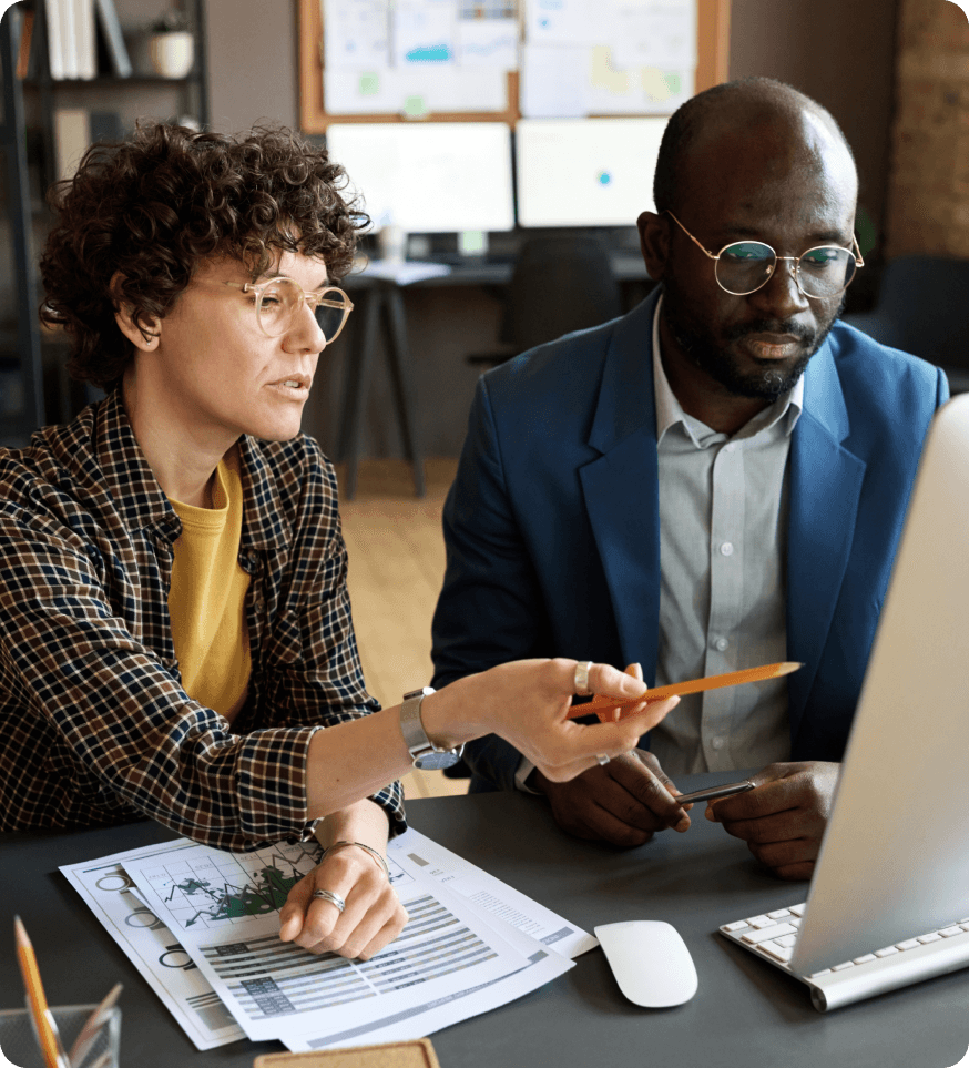 two people in an office, looking at a laptop